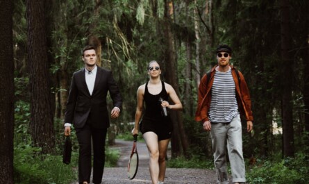 Three people walking in the Helsinki central park during summer